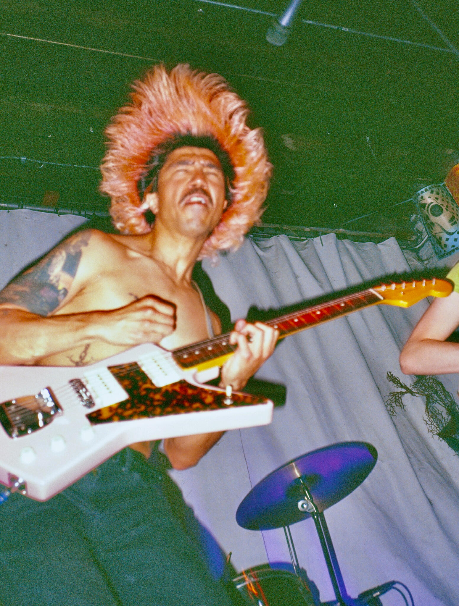 Dan Rico live A photo of Dan rico eyes closed, hair in a halo around his head with jagged-shaped guitar performing live. photo by Zachary Wright
